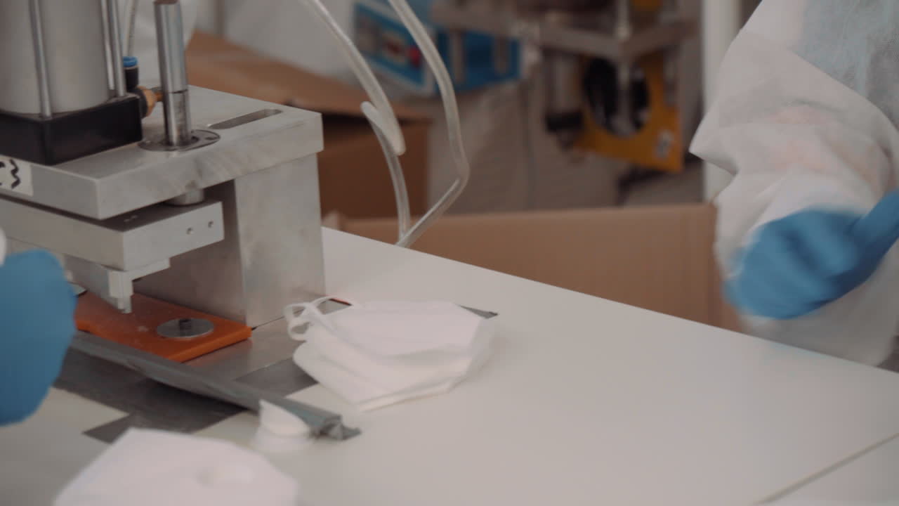 un hombre con traje protector y guantes dobla máscaras faciales