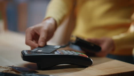 mujer de primer plano con las manos pagando con tarjeta de crédito a través de la terminal en la tienda. pago del cliente