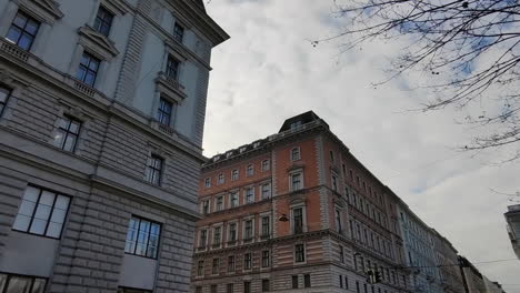 Caminando-Por-Las-Calles-De-La-Ciudad-De-Viena-En-Austria-Con-Vistas-A-Los-Exteriores-De-Los-Edificios-Contra-El-Cielo-Nublado-Blanco