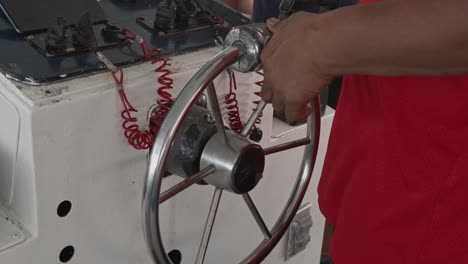 Close-up-shot-of-captain's-hand-steering-directional-wheel