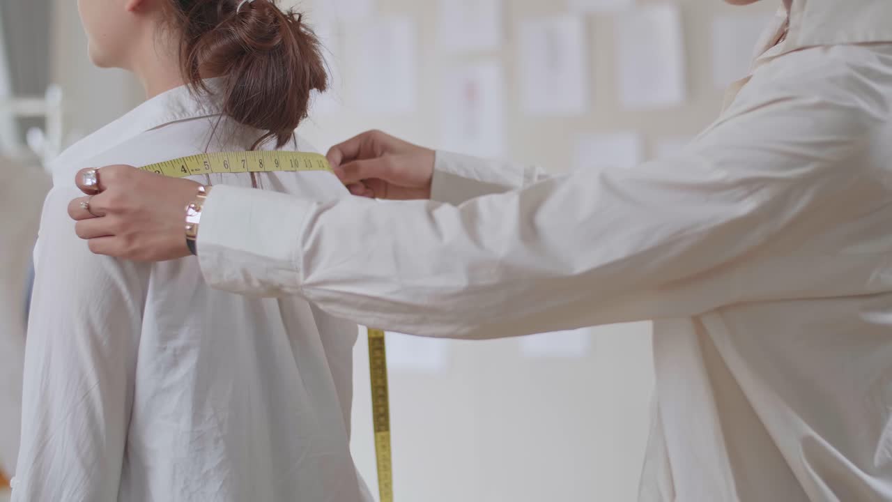 Man Tailor Takes Measures With Female Models. Fashion Designer Sews A Costume For The Model
