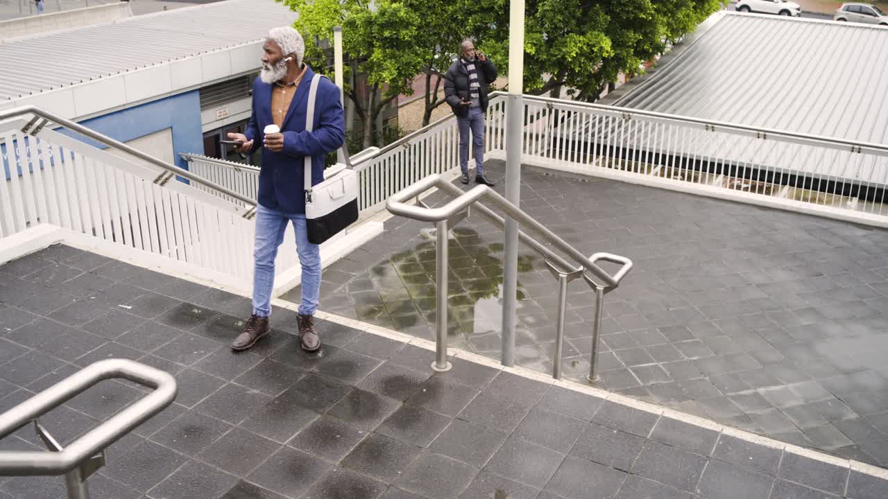 Etter å ha tatt kaffekopp og smarttelefon går en afroamerikansk mann opp gangbroens trapper på vei til jobb