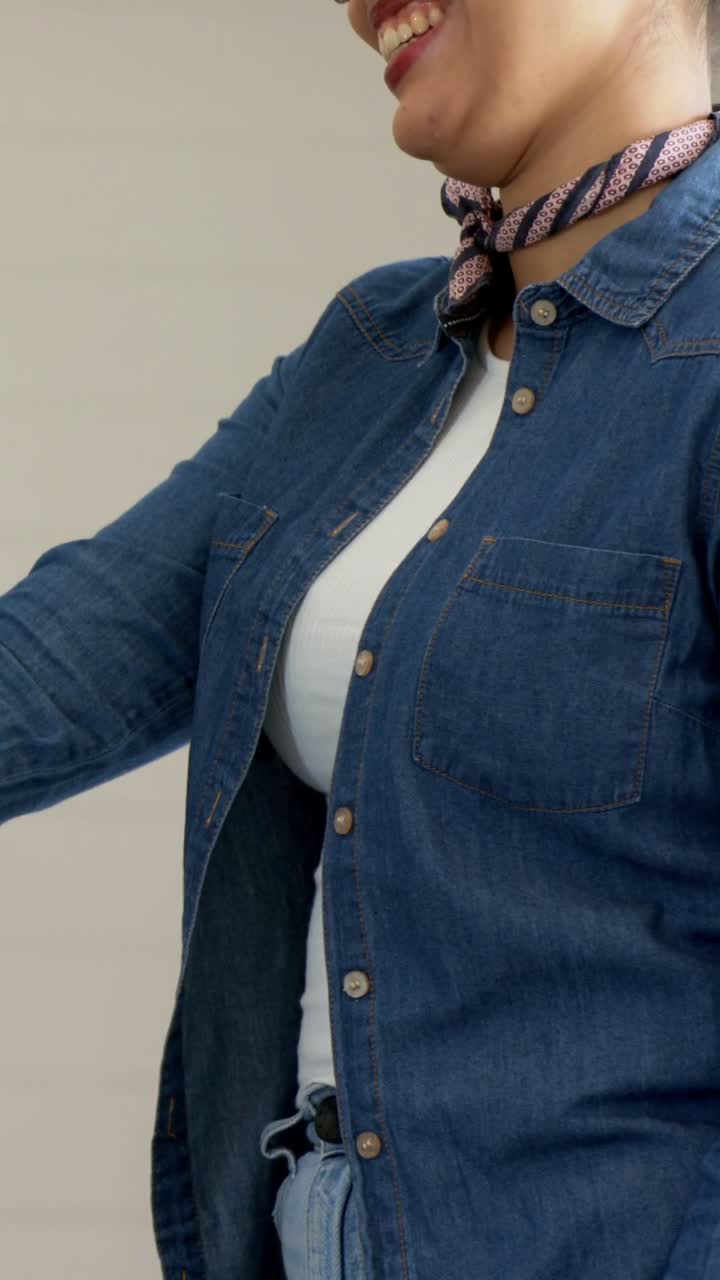 Video verticale: inquadratura di una donna che indossa abiti in denim e che tende la mano all'inizio di una riunione a un tavolo con laptop e tazza