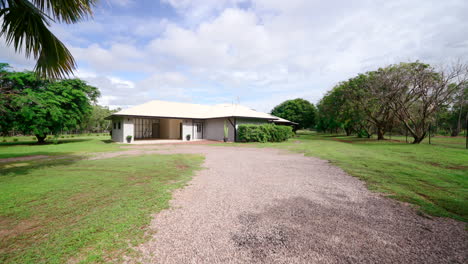 fachada de una lujosa finca rural con entrada de grava que conduce a una casa de un solo piso