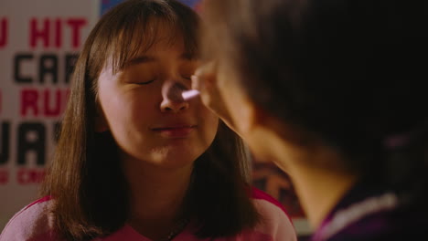 teenage girl getting makeup done