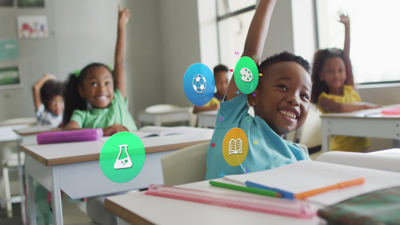 Animation of school subject icons over happy diverse schoolchildren raising hands at desks in class