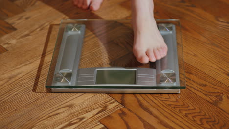 man weighs himself on floor scales 02