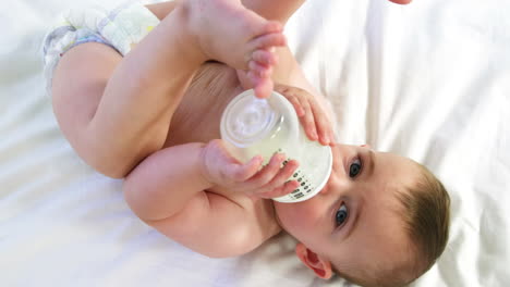 a baby is drinking his feeding bottle