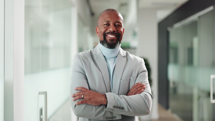 Smiling African American Businessman Standing with Arms Crossed in Office