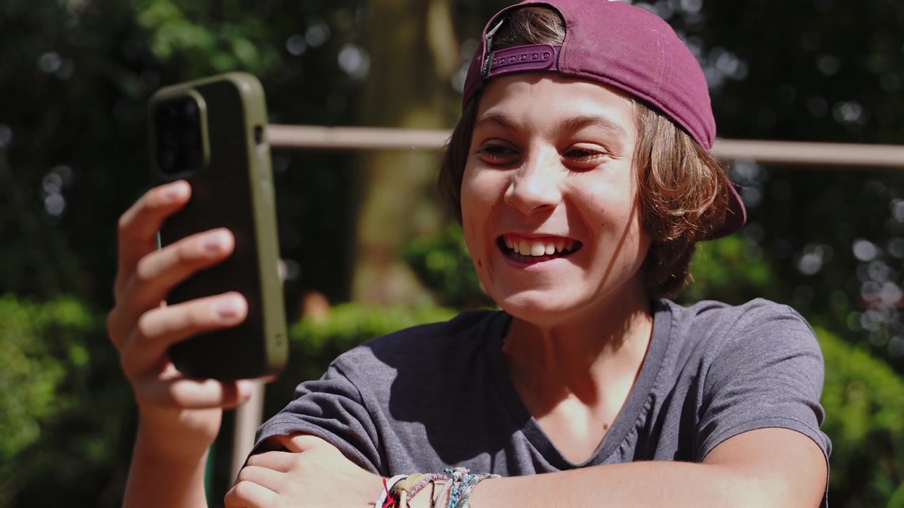 Bambino felice che usa lo smartphone, ragazzo e ragazza che sorridono al telefono.