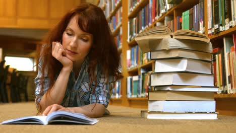 Estudiante-Leyendo-Un-Libro-De-La-Biblioteca