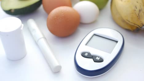 blood glucose meter with fruits and eggs