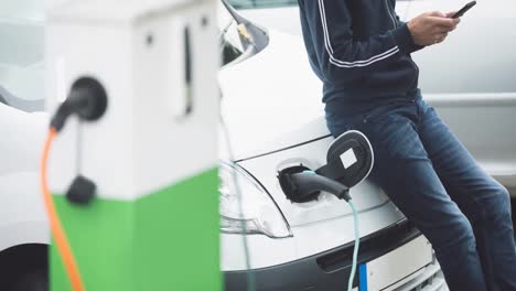 Sección-Media-Del-Hombre-Caucásico-Cargando-Un-Coche-Eléctrico