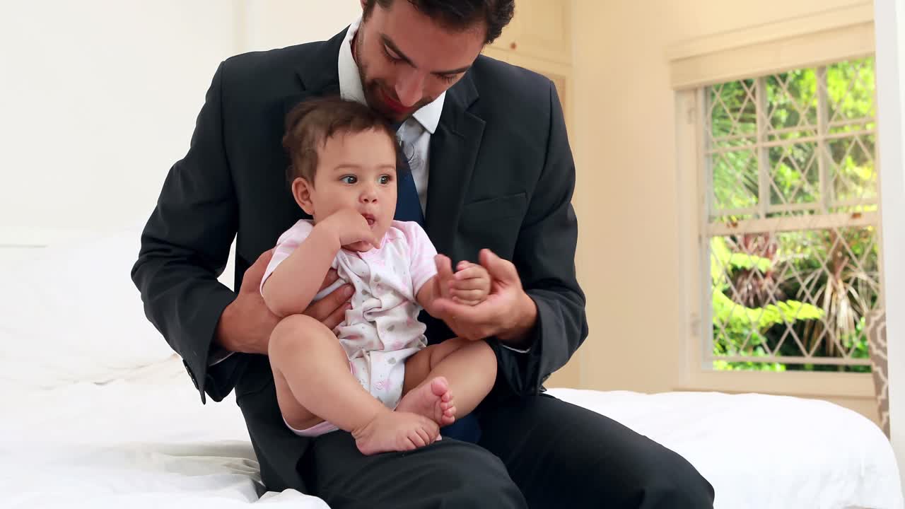 Handsome businessman playing with his baby