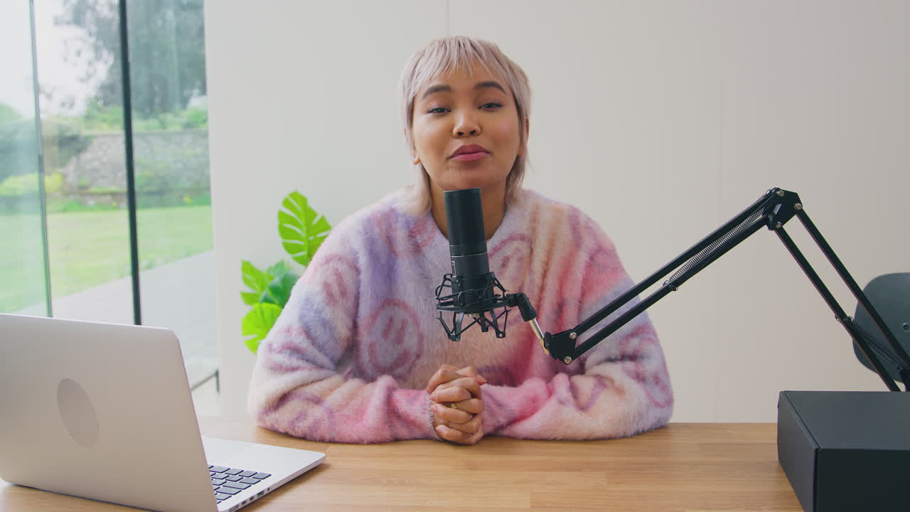 노트북과 마이크를 가진 여성 블로거가 카메라에 온라인 제품 리뷰를 라이브 스트리밍합니다.