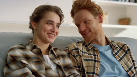 happy married watching tv together closeup. smiling couple talk in living room