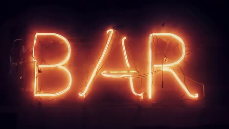 neon sign brightly illuminating the word bar against a dark background, creating a vibrant nightlife atmosphere