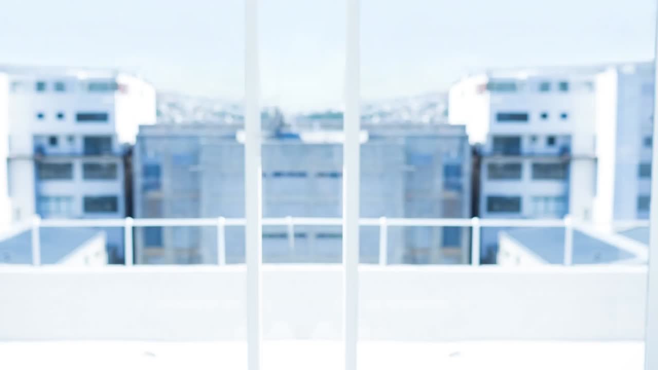 Animation of loading symbol against view of tall building from office balcony