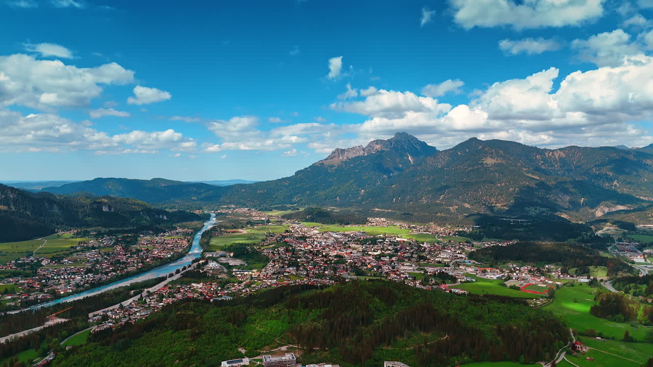 Idyllic view of the picturesque town located in the valley. Woods and mountains surround the residential area. Reutte District, Tyrol, Austria. Aerial perspective.
