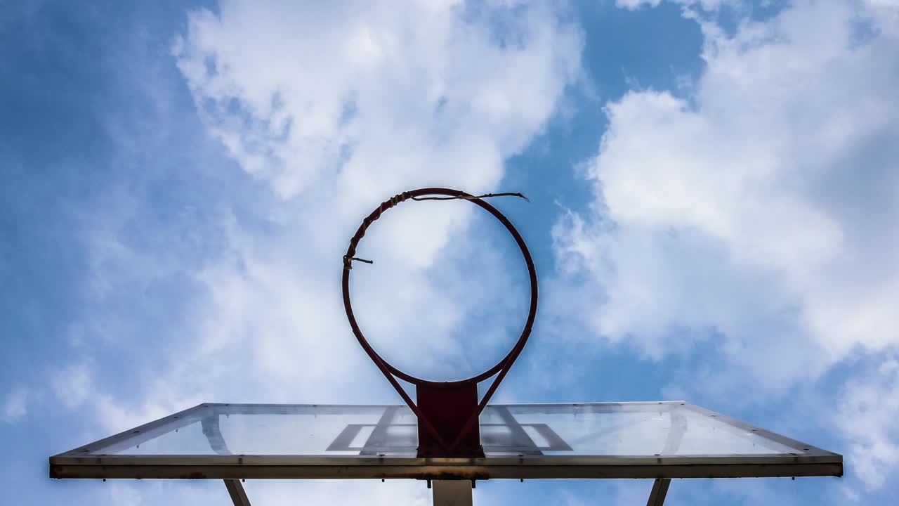 un aro de baloncesto con un fondo de nubes en movimiento