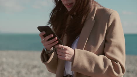 woman using a phone on the beach