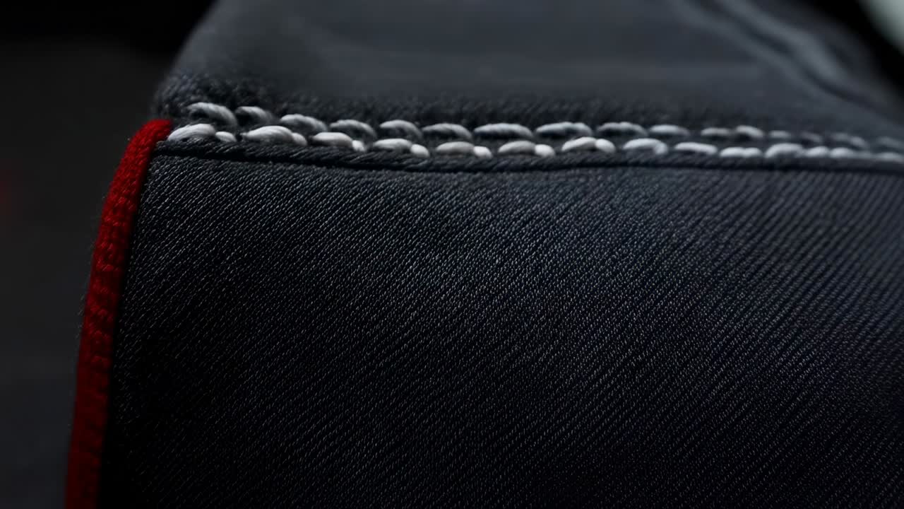 Pulling camera forward, revealing braided white stitch and fibers at cabin seam for texture