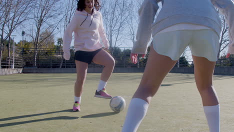 chicas adolescentes enérgicas jugando al fútbol al aire libre