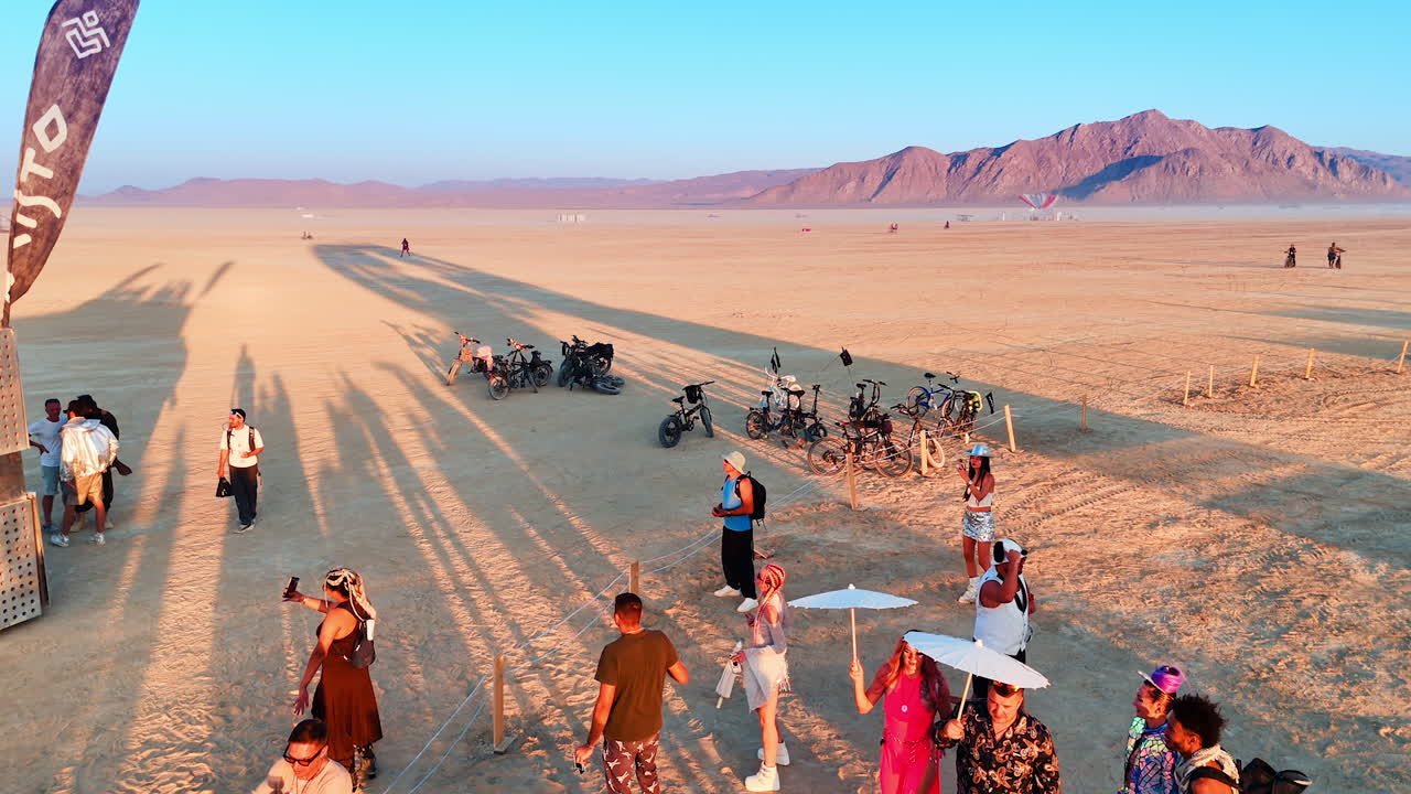 People dance and listen to music in the desert. Having good time at Burning Man festival in the Black Rock Desert