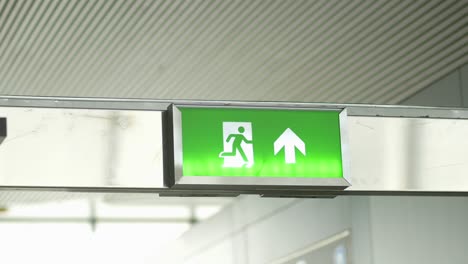 green emergency exit sign with running man and arrow