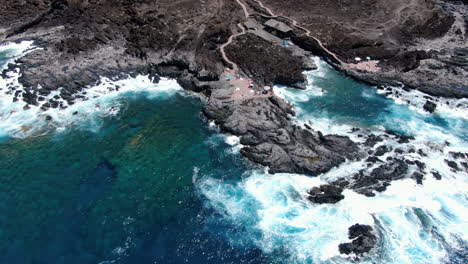 tacoron-beach,-El-Hierro:-fantastic-aerial-view-with-zoom-out-movement-of-one-of-the-natural-pools-with-tourists-bathing