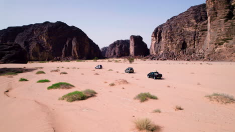 cars driving through the sahara desert in tassili n'ajjer national park in southeastern algeria