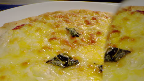 toma macro cortando pizza con queso y salsa de tomate