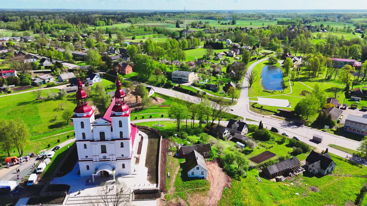 Peaceful scenic aerial fly above ancient religious landmark and dome roofs in Lithuanian village