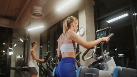 woman working out on cross trainer in gym