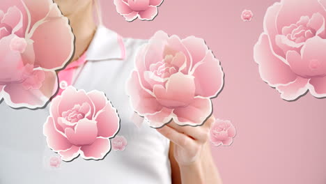 animación de rosas rosadas flotando sobre las manos de una mujer que sostiene una cinta de cáncer de mama, en rosa