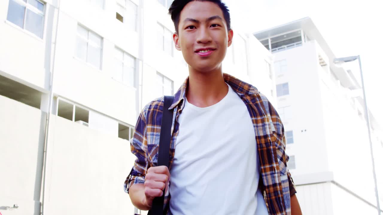 카메라 쪽으로 걸어가며 웃고 있는 남자