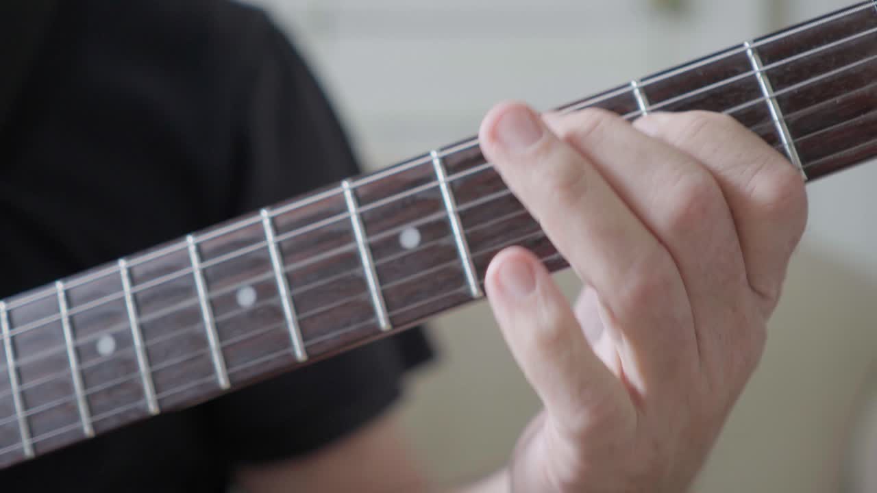 Close-up of a guitarist's left hand improvising on an electric guitar