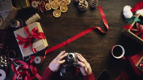 Hände-Von-Oben,-Die-Weihnachtsgeschenke-Am-Holzschreibtisch-Einpacken---Roter-Epischer-Drache