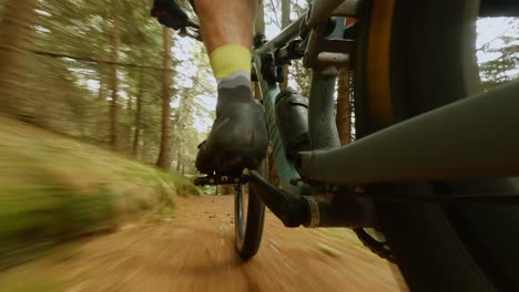 camera focusing on the pedals of a cyclist mountain biking fast