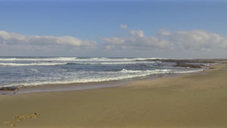 clouds in the sky as the waves gently lap at the shoreline