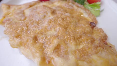 closeup of a fluffy omelette on a white plate