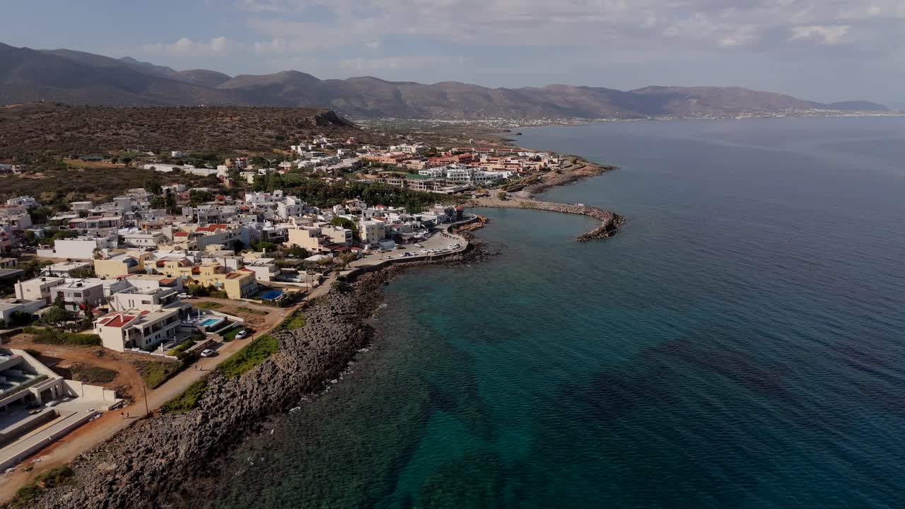 Aerial - transparent waters and rocky coastline near Sissi Village in Crete Greece