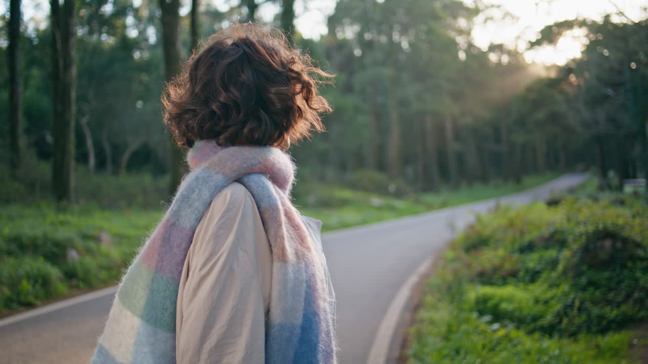 외로운 여자가 공원 길에서 손을 따뜻하게 하는 저녁 빛 클로즈업
