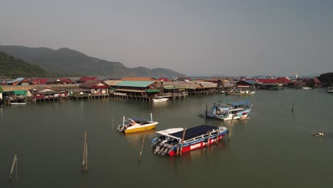 fast aerial shot above the bang bao fishing pier with boats and structures in koh chang, thailand