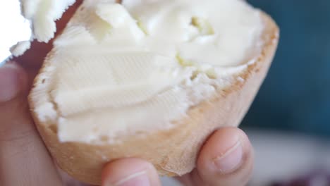 close-up of spreading butter on a piece of bread