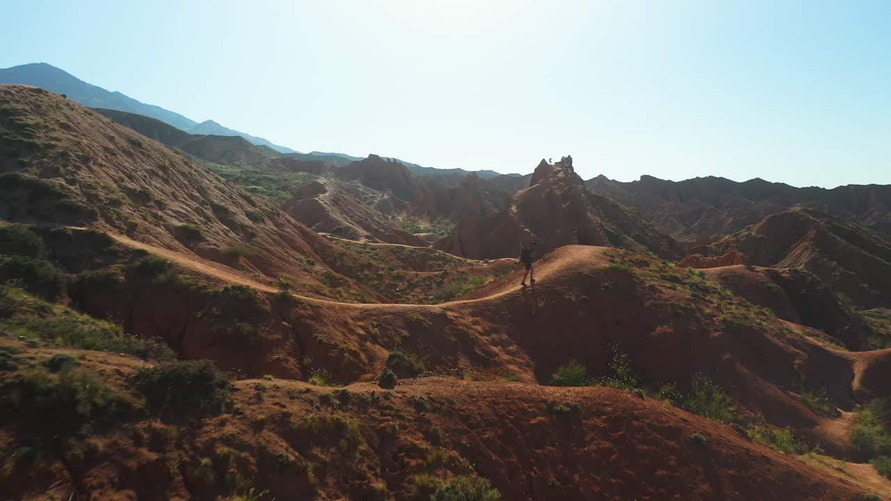 disparo volando sobre las crestas de las montañas en el cañón de cuento de hadas cerca del lago issyk-kul en karakol, kirguistán, imágenes aéreas de drones cinematográficos hacia el sol