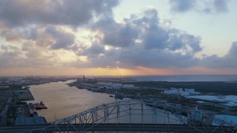 sunsetting behind the corpus christi texas bridge and wind farm nearby