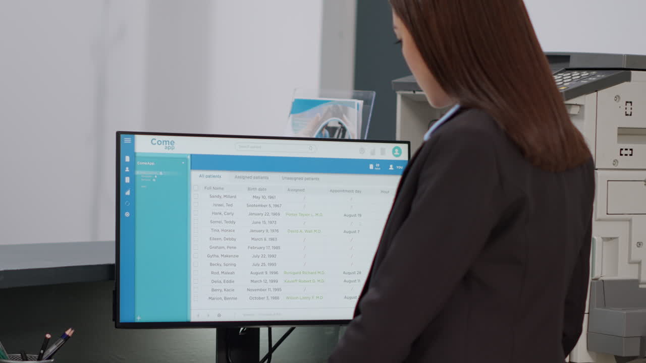 Medical Receptionist Viewing Patient Records on Computer