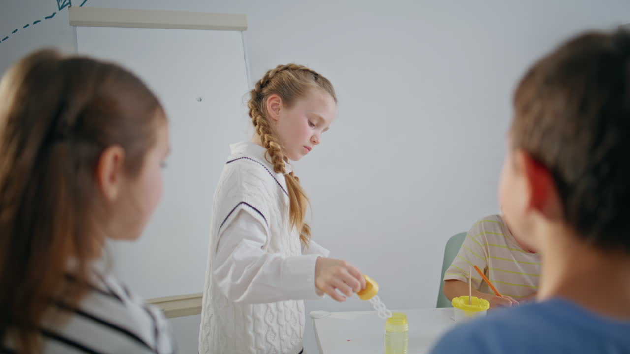 Positive kids playing soap bubbles in school break closeup. Children having fun