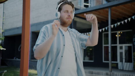 man dancing outdoors with headphones